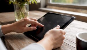Manos interactúan con una tablet mientras configuran el perfil empresarial