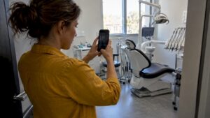 Propietaria tomando fotos de una sala dental para Google
